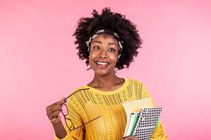 Smiling African American girl student or woman teacher portrait with books in hands. education, high school and people concept - happy smiling young woman teacher in glasses photo