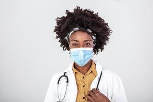 medicine, profession and healthcare concept - close up of african american female doctor or scientist in protective facial mask over grey background photo