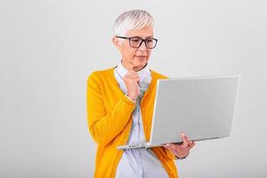 Thoughtful confused mature business woman concerned thinking about online problem looking at laptop, frustrated worried senior middle aged female reading bad email news, suffering from memory loss photo