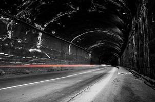 Dark grungy tunnel with red light trails. photo