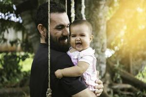 Portrait of father and baby smiling and looking at camera. photo