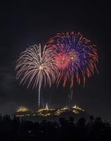 Colorful firework over temple on hill, Thailand photo