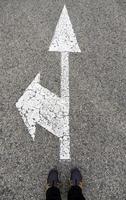 Arrow on the asphalt with feet photo