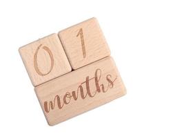 A wooden block showing the date of birth of a newborn child on a white background. photo