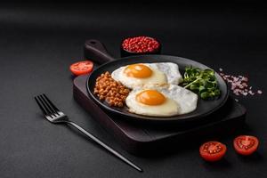 Delicious hearty breakfast consisting of two fried eggs, canned lentils and microgreens photo