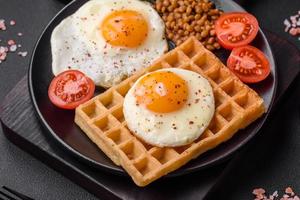 delicioso abundante desayuno consistente de un frito huevo, Belga gofre foto