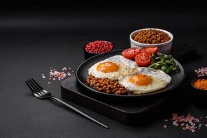 delicioso abundante desayuno consistente de dos frito huevos, Enlatado lentejas y microgreens foto