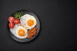 delicioso abundante desayuno consistente de dos frito huevos, Enlatado lentejas y microgreens foto