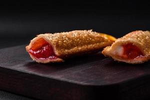 Delicious fresh crispy pie with cherry jam on a wooden cutting board photo