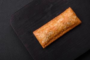 Delicious fresh crispy pie with cherry jam on a wooden cutting board photo