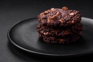 delicioso Fresco harina de avena redondo galletas con chocolate en un negro cerámico plato foto