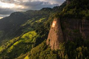 a huge swiss flag is fixed on a cliff photo