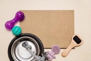 dog toys, a bowl, a wool brush are laid out near an empty brown sheet, copy space, mockup, pets photo