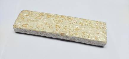 Tempe mentah. Raw tempeh, uncooked soybean cake from indonesia in a plastic on white background photo