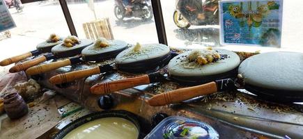 Surakarta, Indonesia, March 12, 2023. Kue leker is a type of Indonesian crepe street food, made with flour, eggs, milk and sugar with various fillings such as banana, chocolate and cheese. Crispy. photo