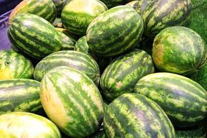 Many big and fresh watermelons on the market,green background photo