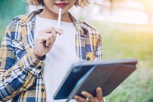 Asian woman using ipad working in garden photo