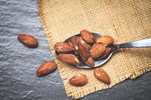 Almonds roasted in a spoon on sack close up almonds nuts baked salt photo