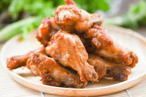 Fried chicken wings on wooden plate - Baked chicken wings BBQ photo