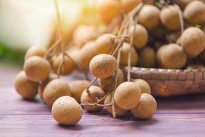 Longan on basket - Dimocarpus longan fruit on wooden background and sunlight  in summer photo