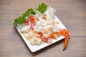 crab meat on white plate with spices for cooked seafood - red crab legs photo