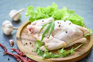 raw chicken with marijuana leaf cannabis herbs and spices on wooden tray - fresh uncooked whole chicken meat marinated with ingredients for cooking