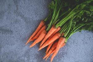 carrot on table background, Fresh and sweet carrots for cooking food fruits and vegetables for health concept, baby carrots bunch and leaf photo