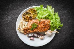 chicken breast grilled with garlic chilli herbs and spices and fresh vegetables on plate top view - Roast BBQ chicken breast steak photo