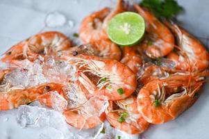 camarón en Mariscos plato y de madera antecedentes comida mesa alimento, Fresco camarones langostinos limón Lima con hierbas y especia foto