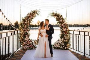 bride and groom against the backdrop of a yellow sunset photo