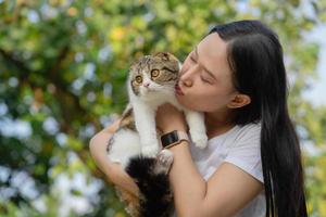 asiático mujer participación su linda mullido gato. linda gatito marrón modelo. mascotas y estilo de vida concepto. foto