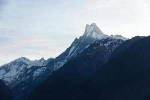 un hermosa ver de el cumbre de machapuchare alias el cola de pescado montaña desde el pueblo de chomrong en el Annapurna base acampar sendero en el Nepal himalaya foto