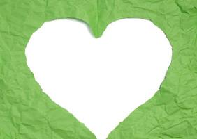 A heart cut out of green paper on a white isolated background, an element for a designer. photo