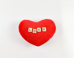 plano laico de r de madera letras l o v mi en rojo corazón forma almohada en blanco antecedentes. San Valentín día concepto. foto