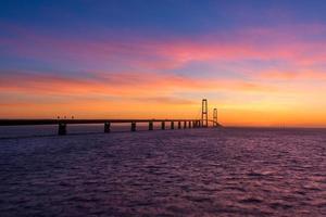 The Great Belt bridge in Denmark during a very colorful sunset photo