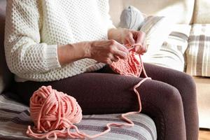 de cerca de De las mujeres manos tejido de punto un acogedor de lana artículo. hecho a mano ropa. foto