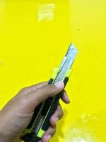 Side view of black yellow utility knife photo