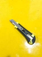Side view of black yellow utility knife photo