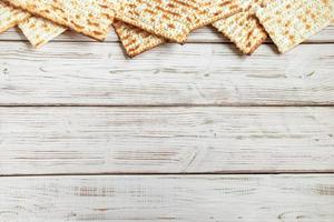 Happy Passover concept. Matzah background. Traditional Jewish regilious holiday of Pesach. Frame made of matzo bread on a white wooden table. photo