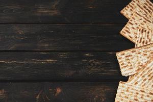 Matzo bread on a dark wooden background. Happy Passover. Traditional Jewish regilious holiday Pesach. Copy space. photo