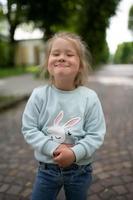 A little girl smiles funny at the camera. Close-up. photo