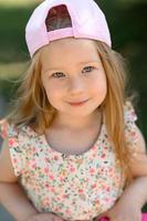Little girl 3 years old in a pink cap. Close-up. Summer time. photo