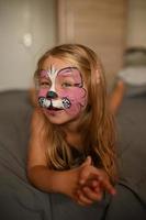 Little girl 3 years old with a painted face. photo