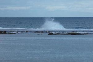 Large waves crashing against the rocks in the ocean photo