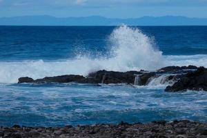 Large waves crashing against the rocks in the ocean photo