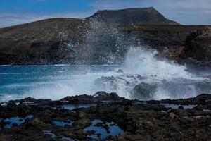 Large waves crashing against the rocks in the ocean photo