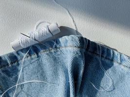 needle and thread. mending jeans photo