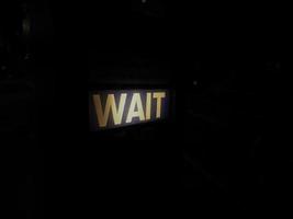 Wait sign at pedestrian crossing at night in London photo