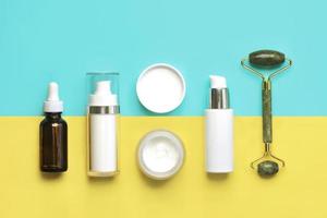 Set of cosmetics and jade massanger roller for skin care. Skin care products concept photo