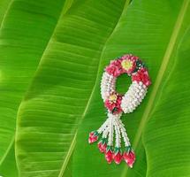 Handmade jasmine garland, a symbol of Mother's Day in Thailand. on banana leaf background photo